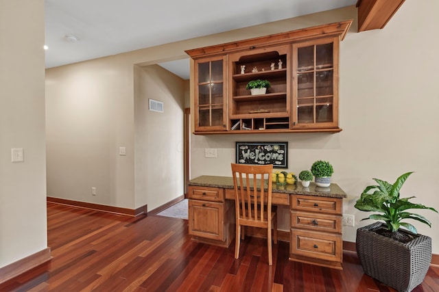 office featuring dark hardwood / wood-style flooring and built in desk