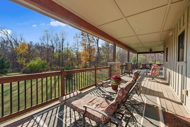 wooden deck with ceiling fan and a yard