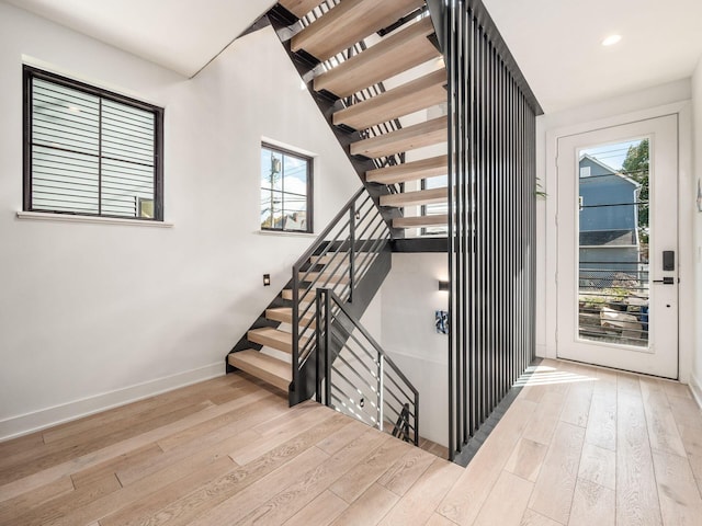 stairs with hardwood / wood-style flooring and plenty of natural light