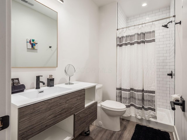 bathroom featuring a shower with curtain, hardwood / wood-style floors, vanity, and toilet