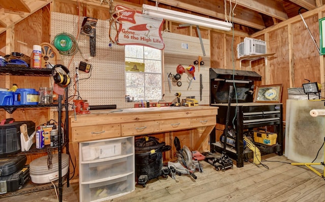 miscellaneous room featuring a workshop area, wood-type flooring, and a wall unit AC