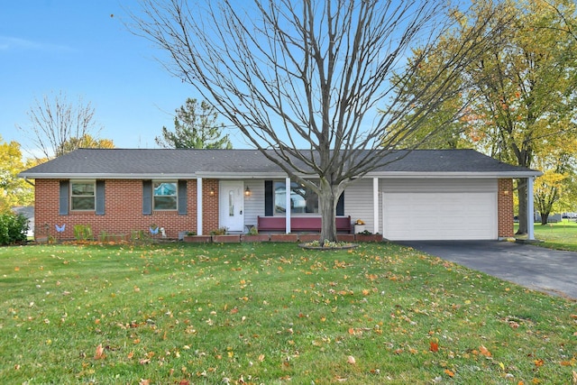 single story home with a garage, aphalt driveway, a front yard, and brick siding