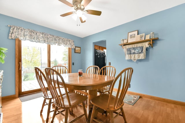 dining space with a ceiling fan, light wood-type flooring, and baseboards