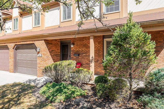 property entrance with a garage and brick siding