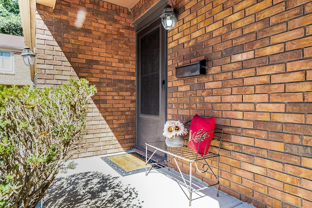 entrance to property featuring brick siding