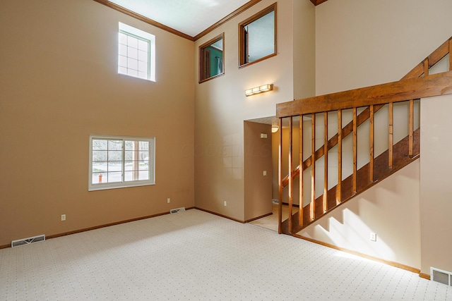 interior space featuring ornamental molding, carpet flooring, visible vents, and baseboards