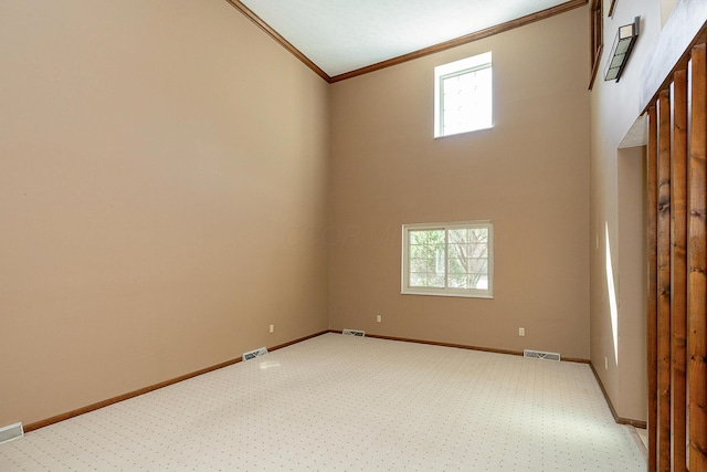 spare room with plenty of natural light, visible vents, and ornamental molding