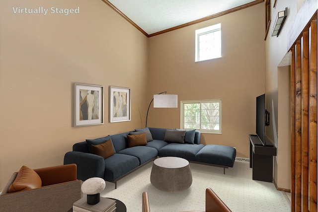 living room featuring a towering ceiling, baseboards, and ornamental molding