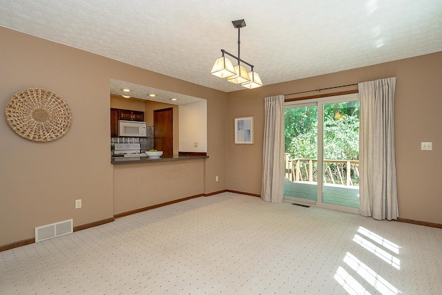 interior space featuring visible vents, a textured ceiling, and baseboards