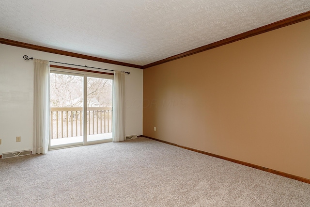 carpeted spare room with a textured ceiling, ornamental molding, visible vents, and baseboards