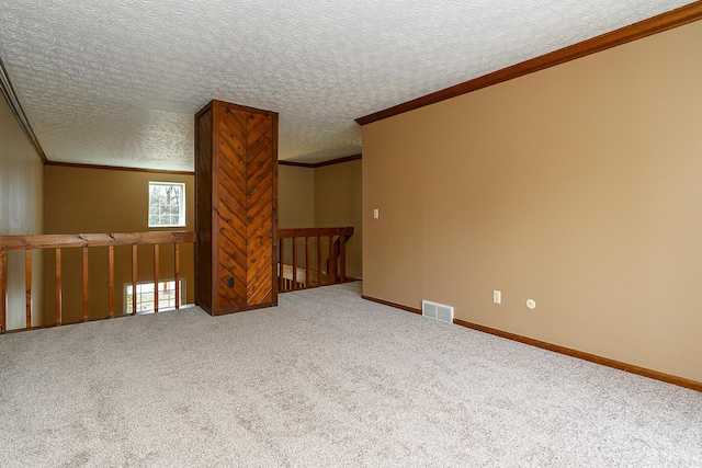 unfurnished room featuring carpet floors, baseboards, visible vents, and crown molding