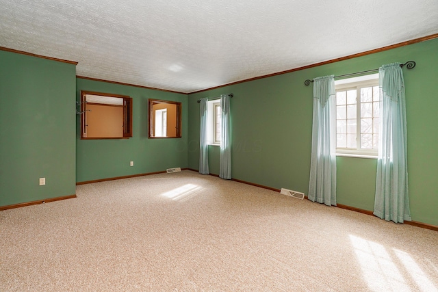 spare room featuring visible vents, crown molding, and light colored carpet