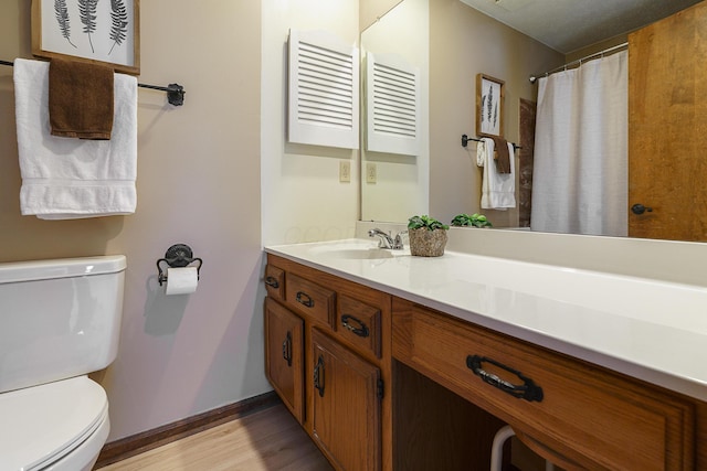 full bath featuring baseboards, vanity, toilet, and wood finished floors