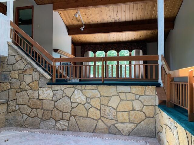 interior space featuring vaulted ceiling with beams and wood ceiling