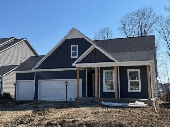 view of front of house with a porch, a garage, driveway, and board and batten siding