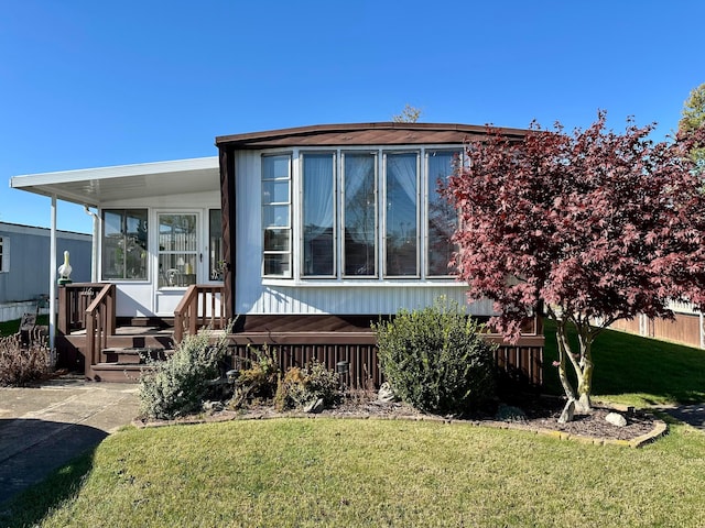 back of house with a lawn and a sunroom