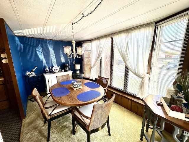 carpeted dining room featuring a notable chandelier, a textured ceiling, and wooden walls