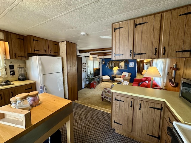 kitchen with dark colored carpet, white refrigerator, stove, and a textured ceiling