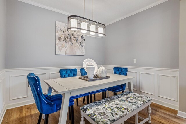 dining space with light hardwood / wood-style floors and crown molding