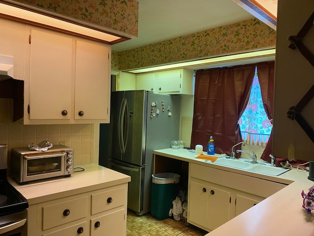 kitchen featuring stainless steel appliances, white cabinetry, tasteful backsplash, and sink