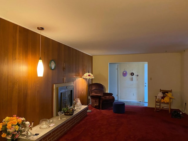 carpeted living room with a brick fireplace and wood walls