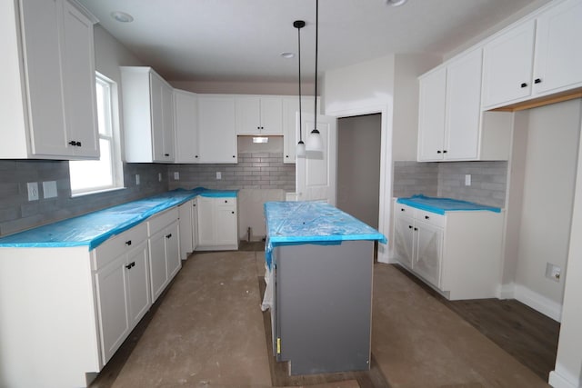 kitchen featuring decorative light fixtures, a kitchen island, and white cabinets