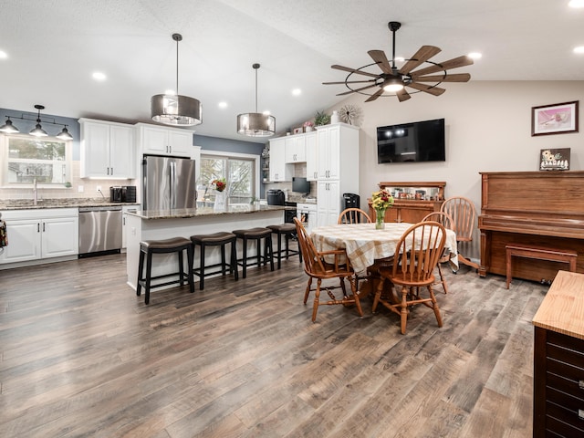 dining area with dark hardwood / wood-style flooring, vaulted ceiling, ceiling fan, and sink