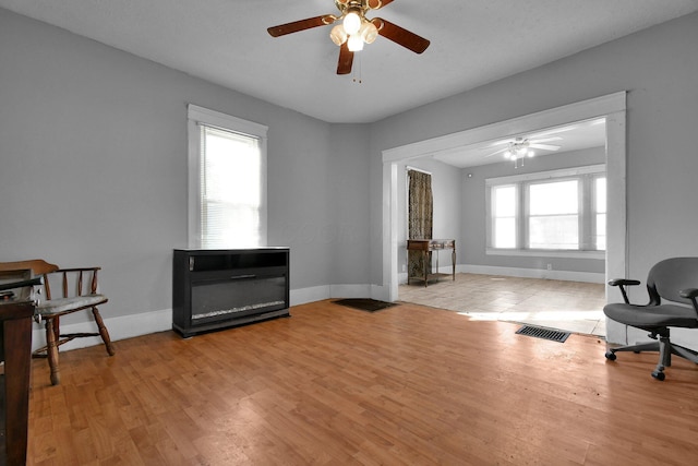 sitting room with light wood-type flooring and ceiling fan