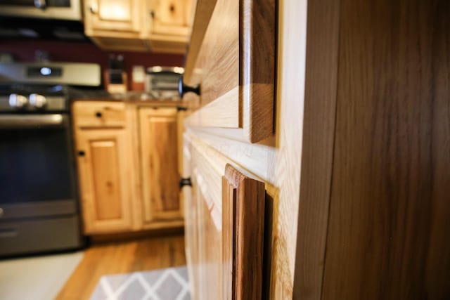 kitchen featuring black electric range oven and light hardwood / wood-style floors