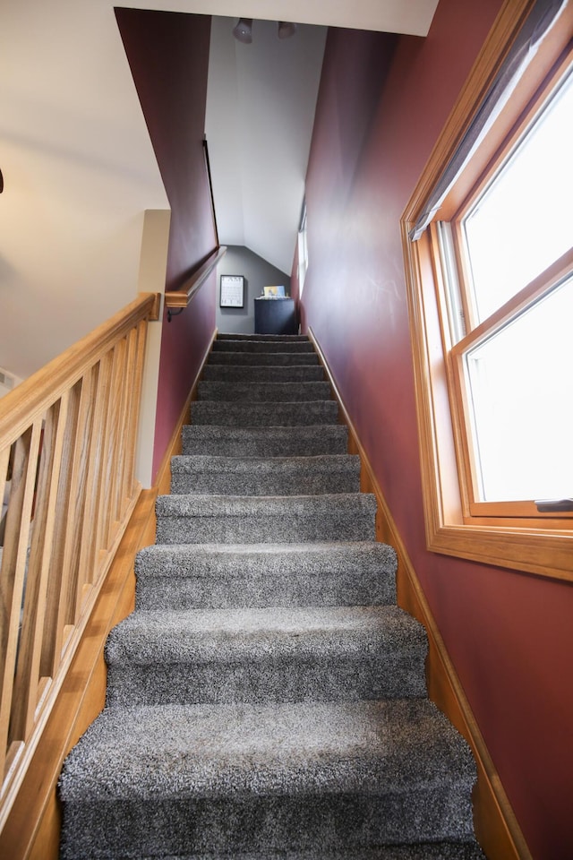 stairway featuring hardwood / wood-style floors and vaulted ceiling