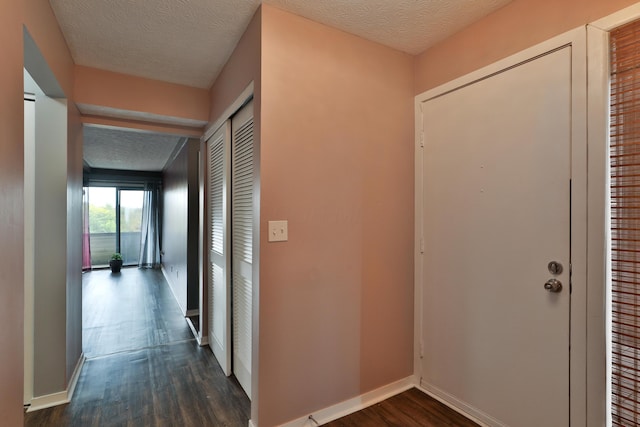 hallway featuring a textured ceiling and dark wood-type flooring