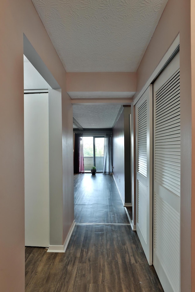 hall featuring dark hardwood / wood-style flooring and a textured ceiling