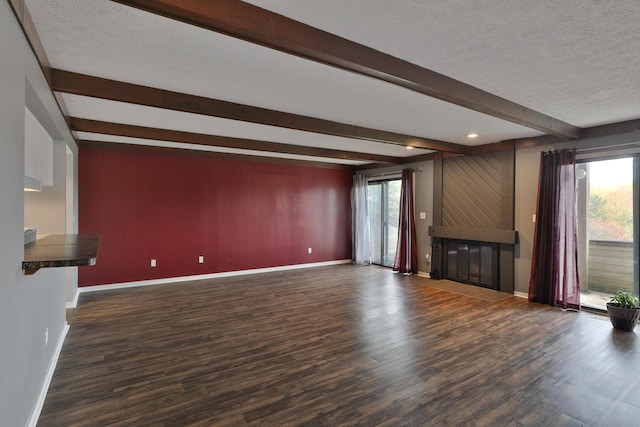 unfurnished living room with beam ceiling, a textured ceiling, and dark hardwood / wood-style floors