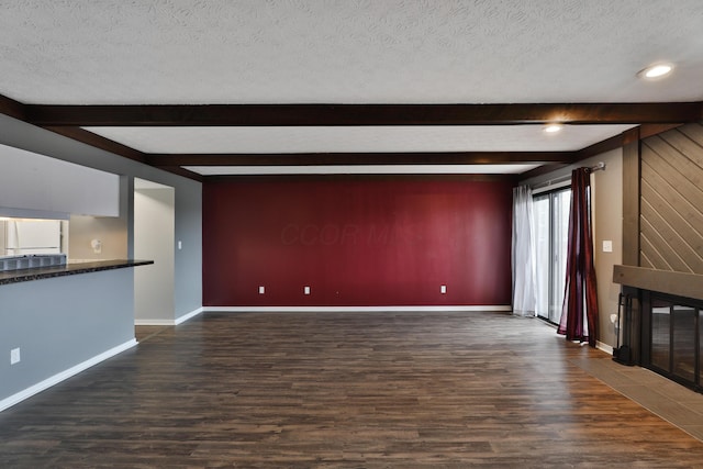 unfurnished living room featuring a textured ceiling, beamed ceiling, and dark hardwood / wood-style floors