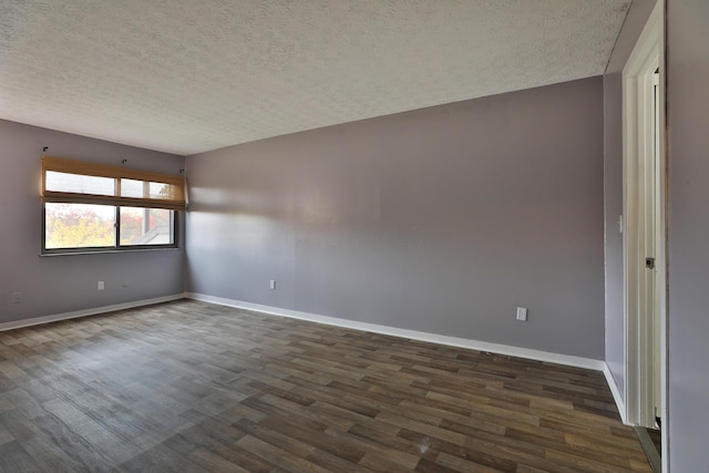 spare room featuring a textured ceiling and dark hardwood / wood-style floors