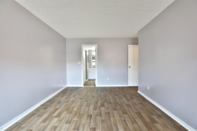 spare room featuring hardwood / wood-style flooring and a textured ceiling