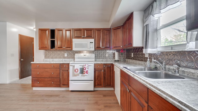 kitchen featuring tasteful backsplash, light hardwood / wood-style flooring, white appliances, and sink