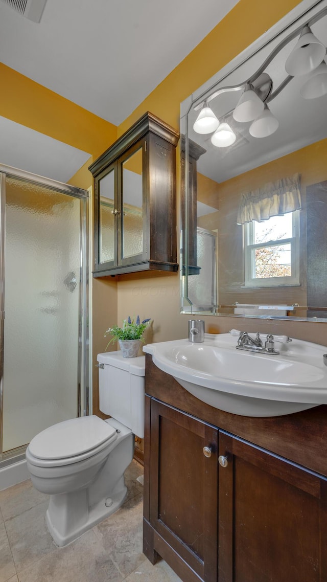 bathroom featuring tile patterned floors, vanity, an enclosed shower, and toilet