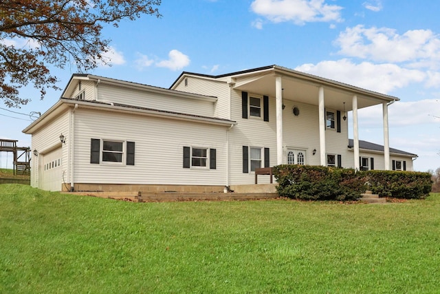 rear view of property with a yard and a garage