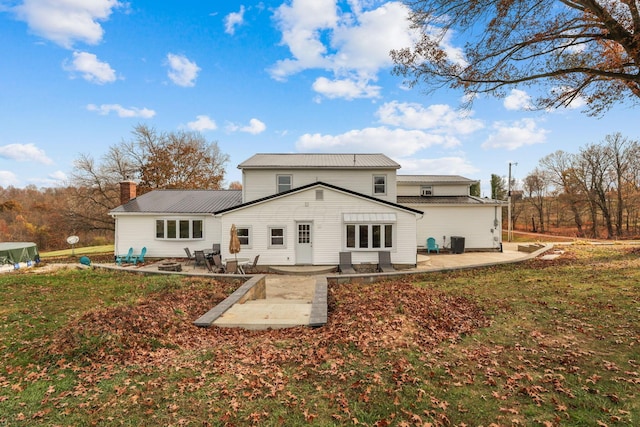 back of property with a yard and a patio