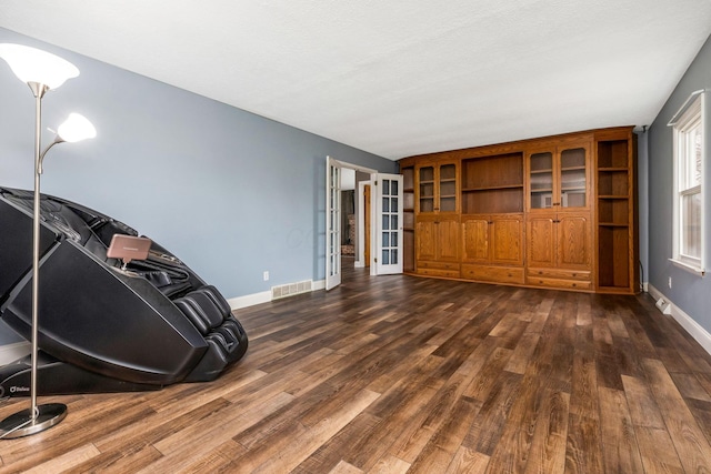 unfurnished living room with dark hardwood / wood-style flooring and a textured ceiling