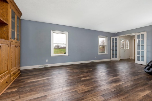 spare room with french doors and dark hardwood / wood-style flooring