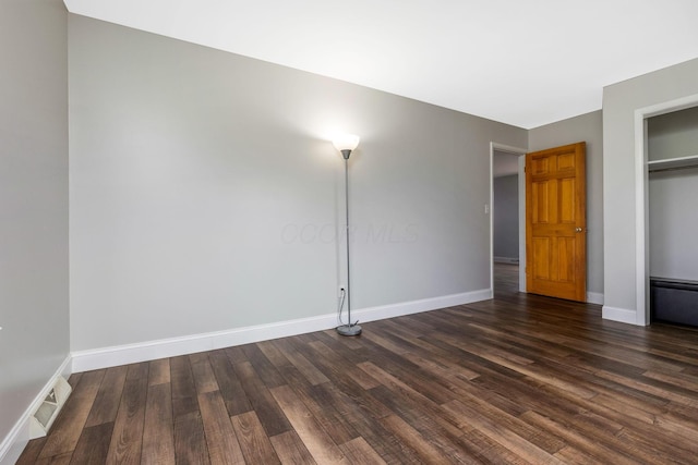 unfurnished bedroom with a closet and dark hardwood / wood-style floors