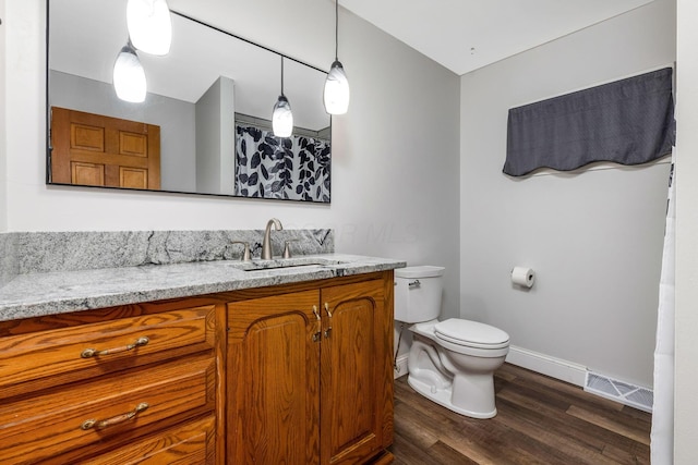 bathroom with vanity, wood-type flooring, and toilet