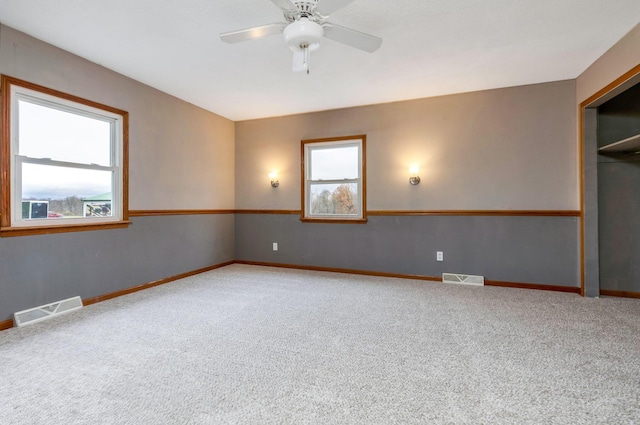 carpeted spare room with ceiling fan