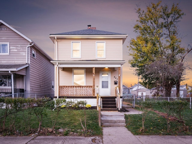 view of front of house with a porch and a yard