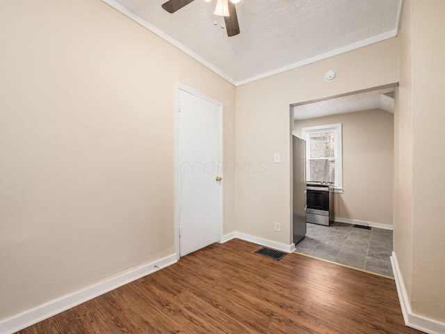 spare room featuring a textured ceiling, ceiling fan, crown molding, light hardwood / wood-style flooring, and lofted ceiling