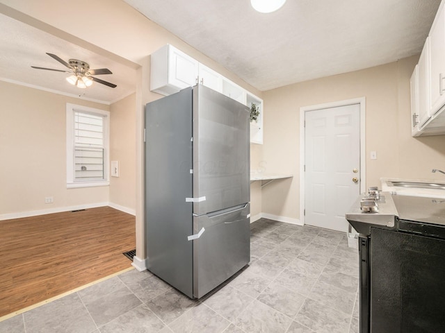 kitchen featuring stainless steel fridge, ornamental molding, sink, white cabinets, and light hardwood / wood-style floors