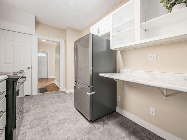 kitchen with white cabinets, appliances with stainless steel finishes, and light stone countertops