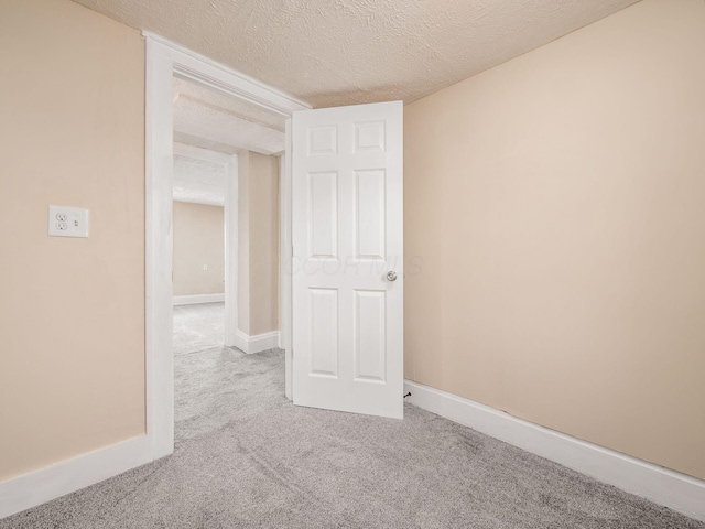 empty room with carpet floors and a textured ceiling